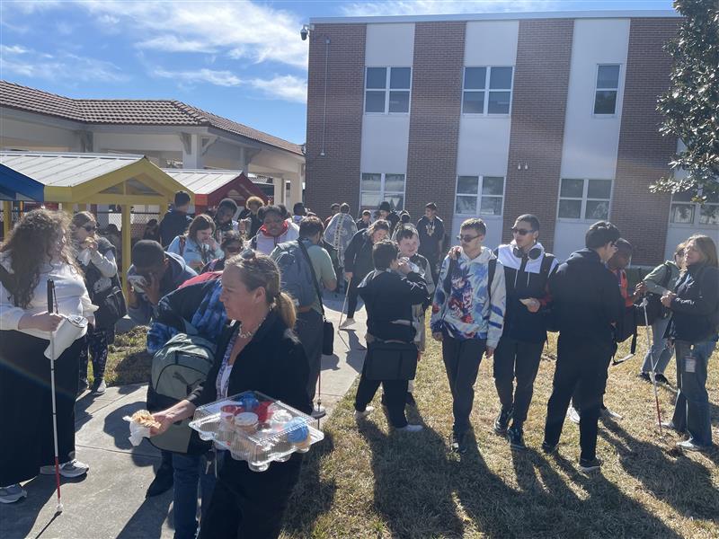 Students gathered on the playground while cupcakes are handed out