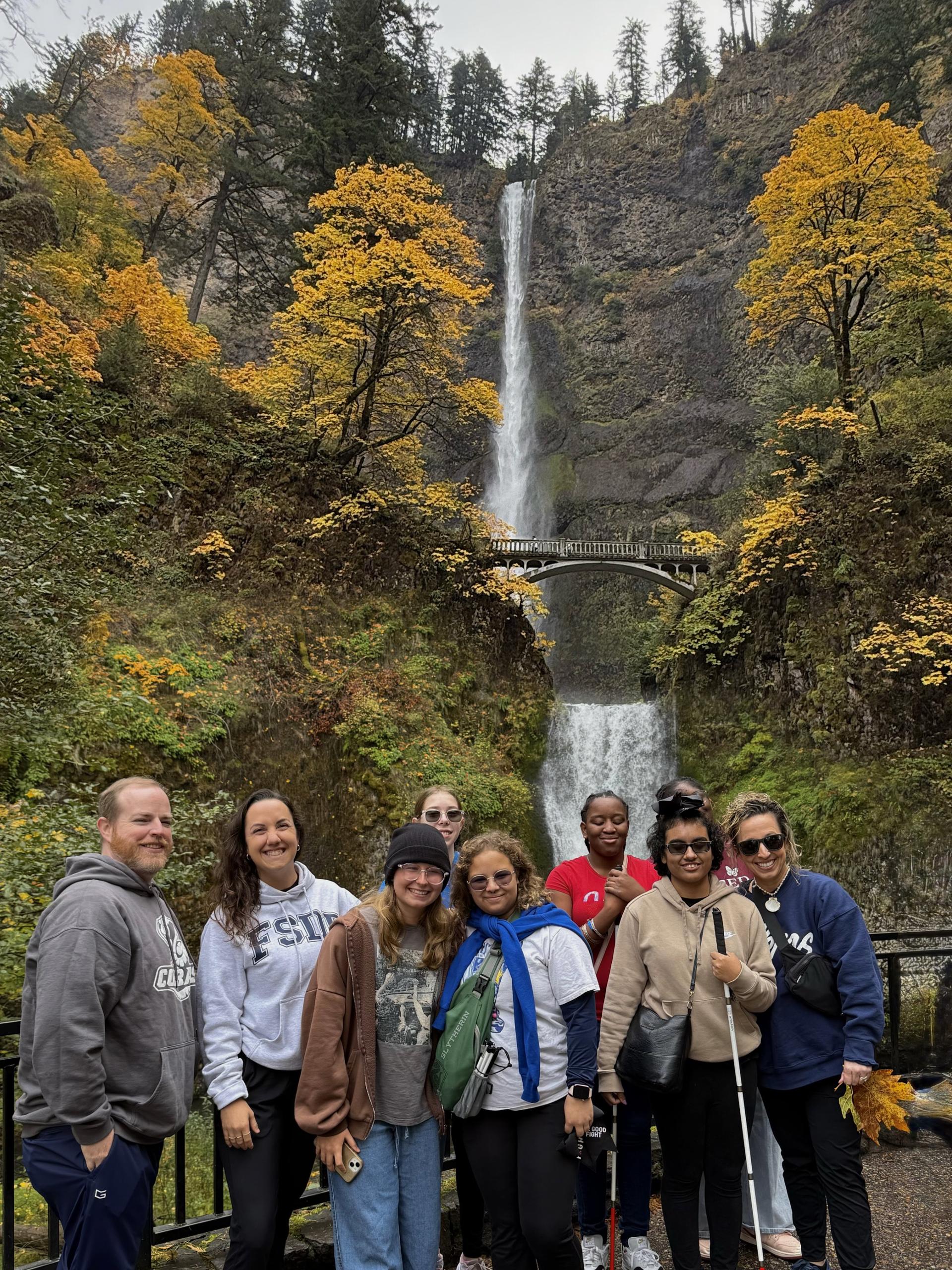 Team standing in front of the waterfall