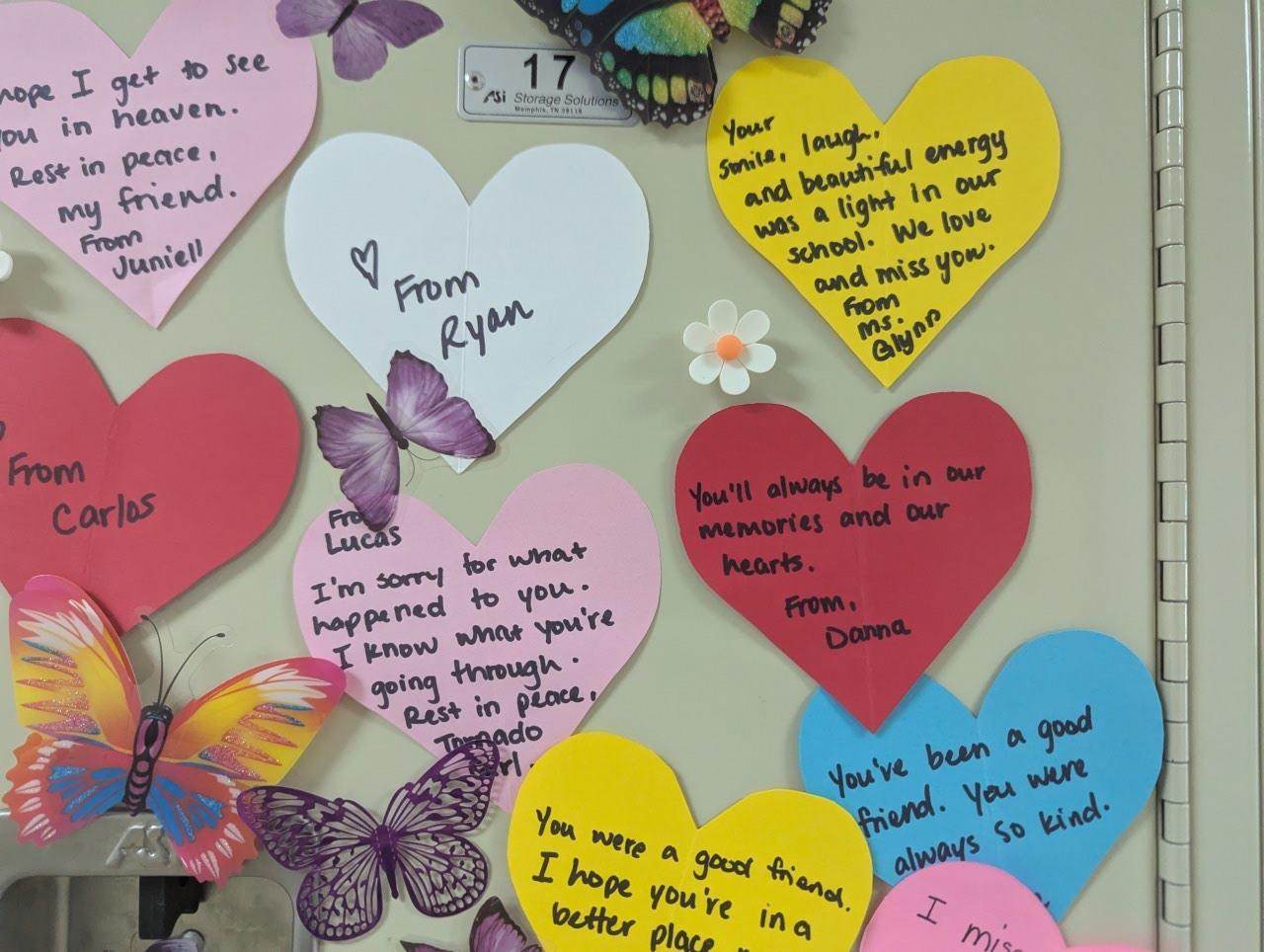 butterflies and words from friends and teachers written on colored heart paper