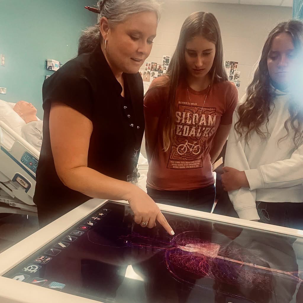 photo of teacher with two high school students