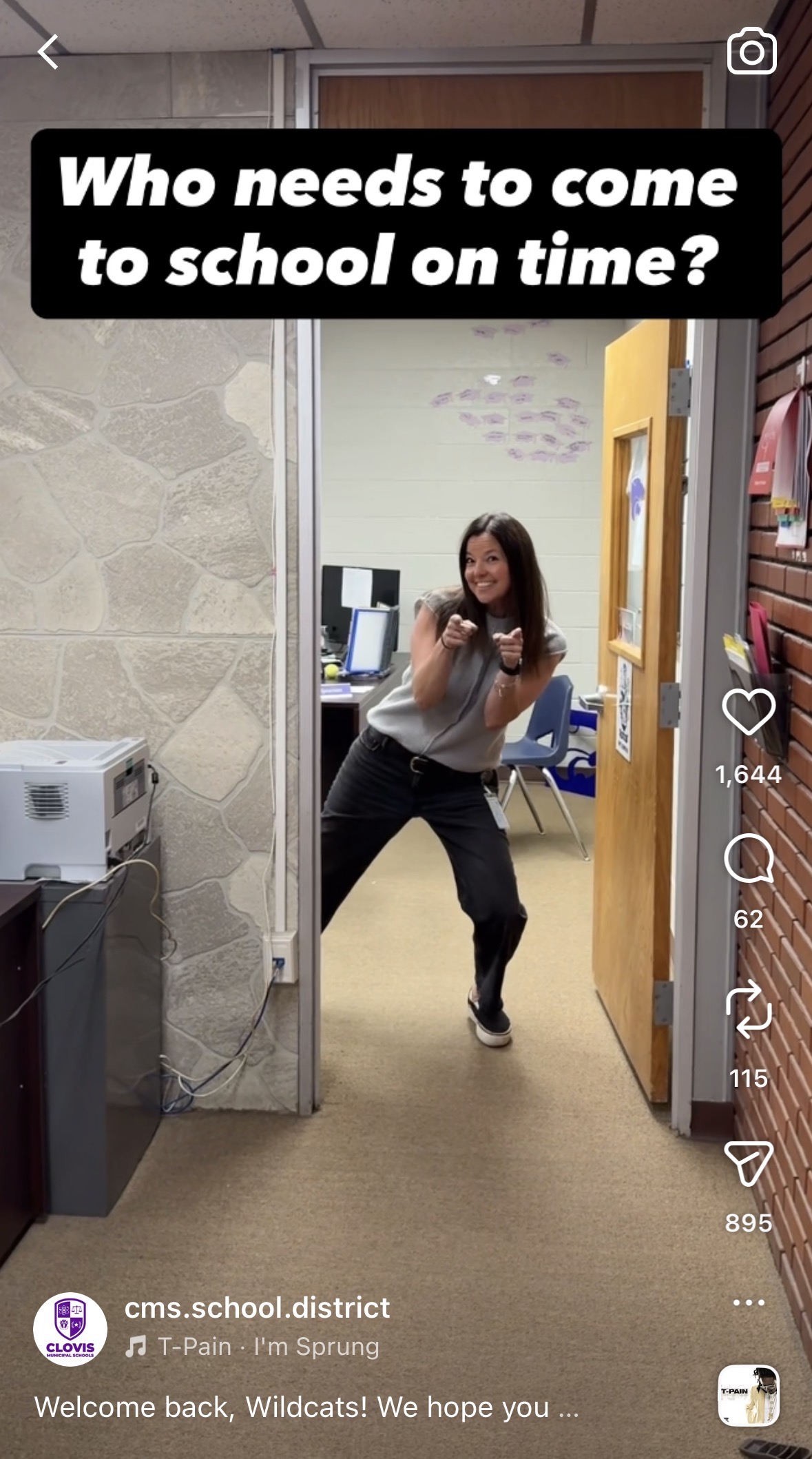 Teacher standing in a doorway pointing at a camera