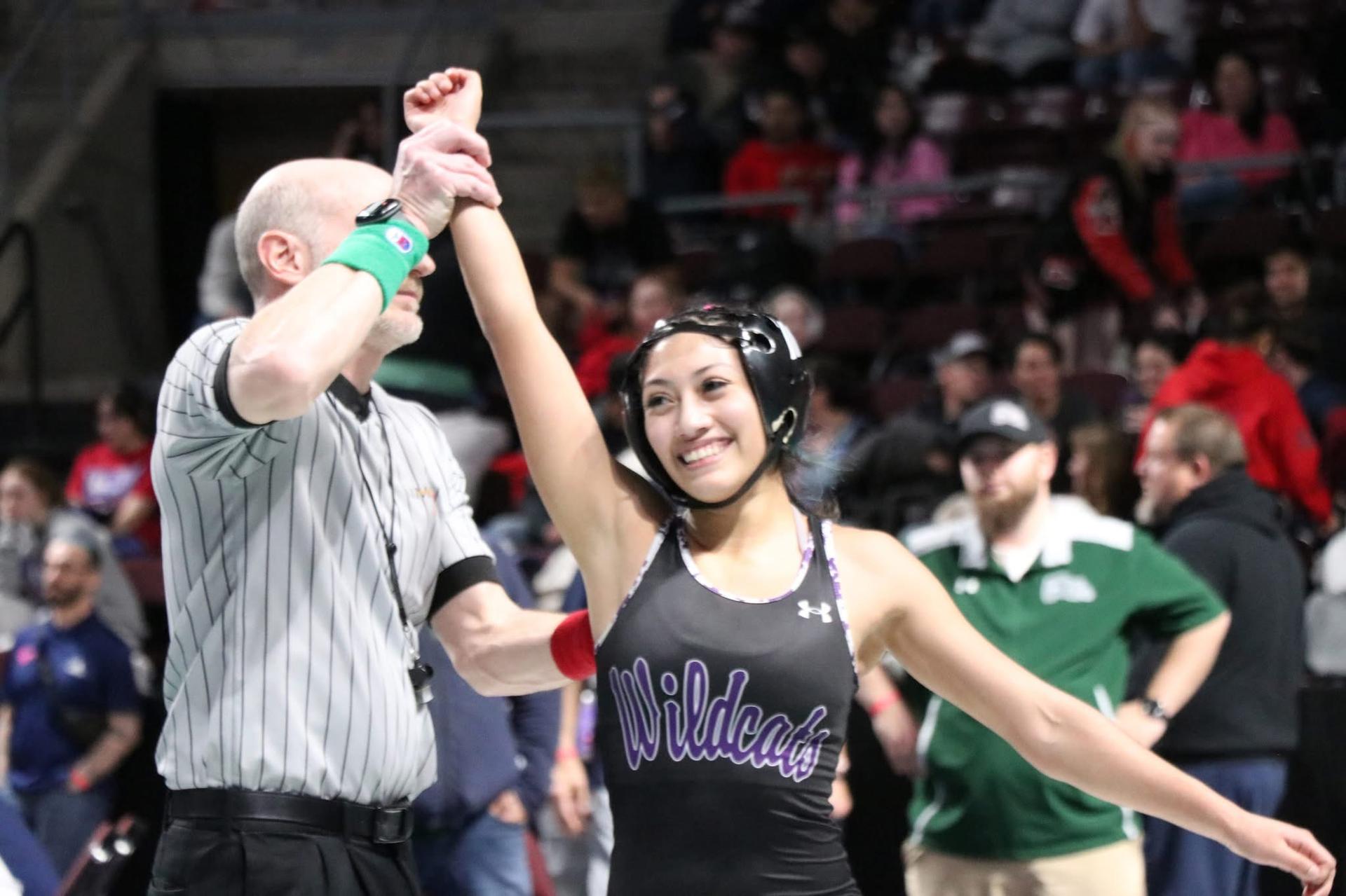 Girls Wrestling Athlete with an arm raised in victory