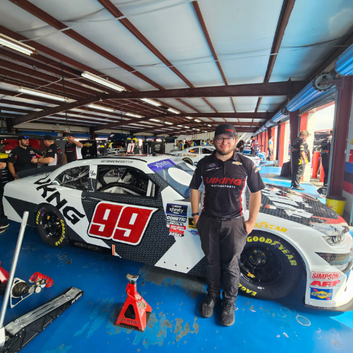 Two smiling Eastland students hold a bright pink photo frame decorated with the words 