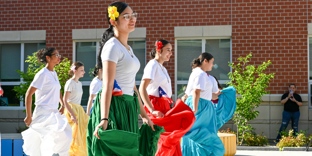 Students dancing in long skirts and flowers in their hair