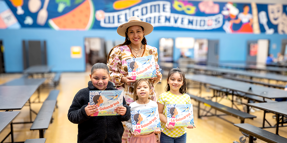 Author and three students holding copies of her book