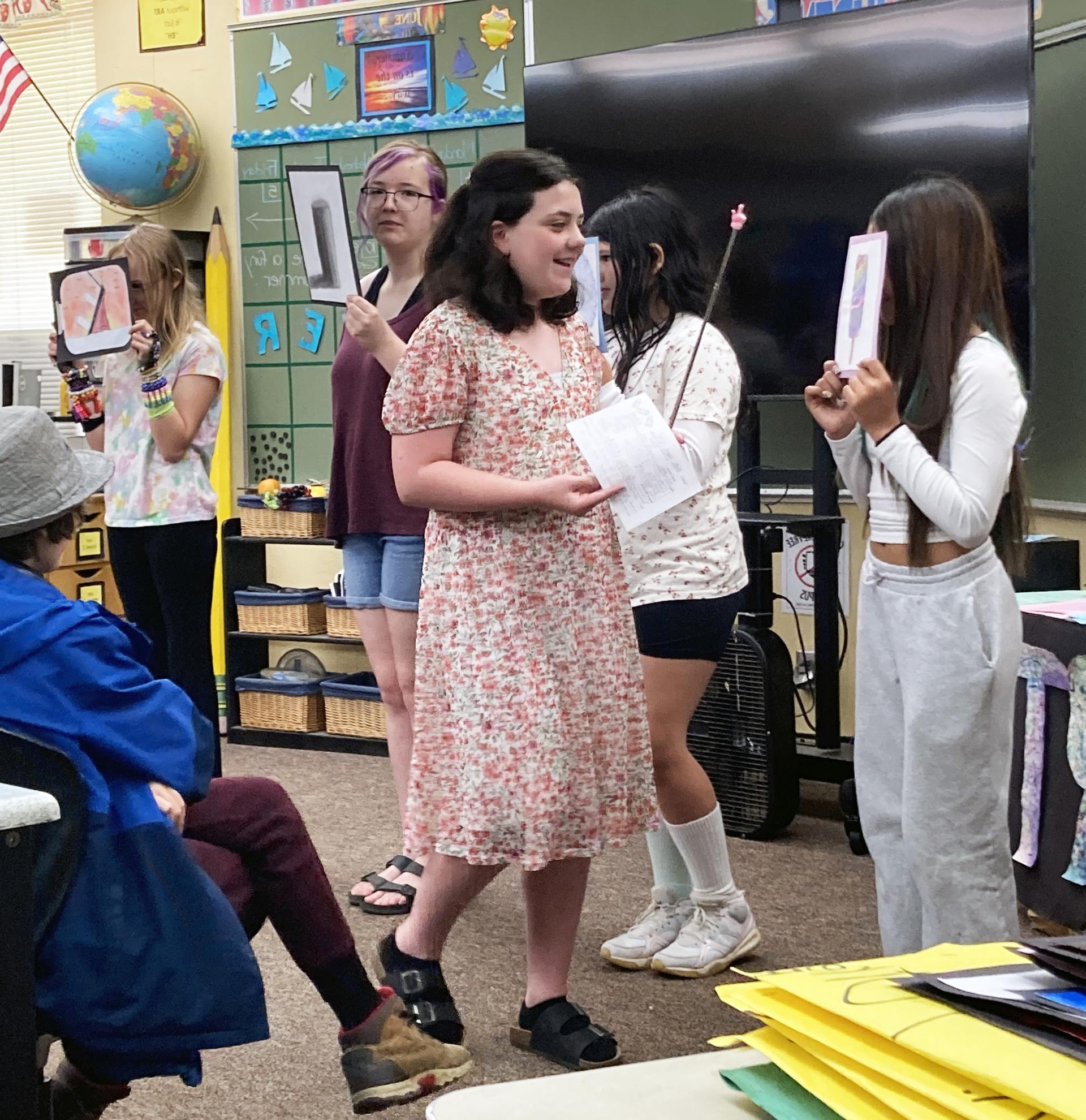 A student presents their artwork to peers and family members.