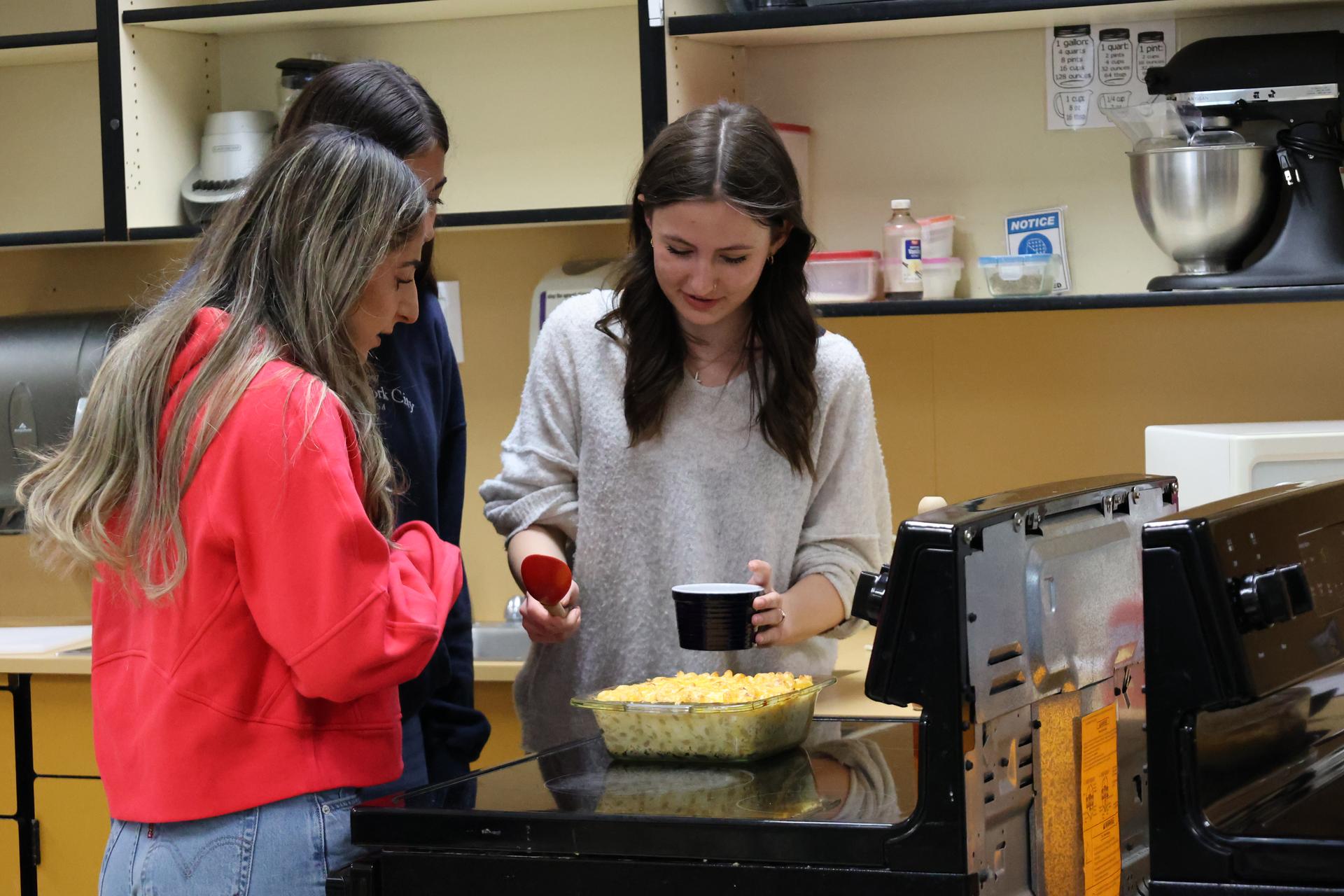 Two culinary arts students serve up mac and cheese 