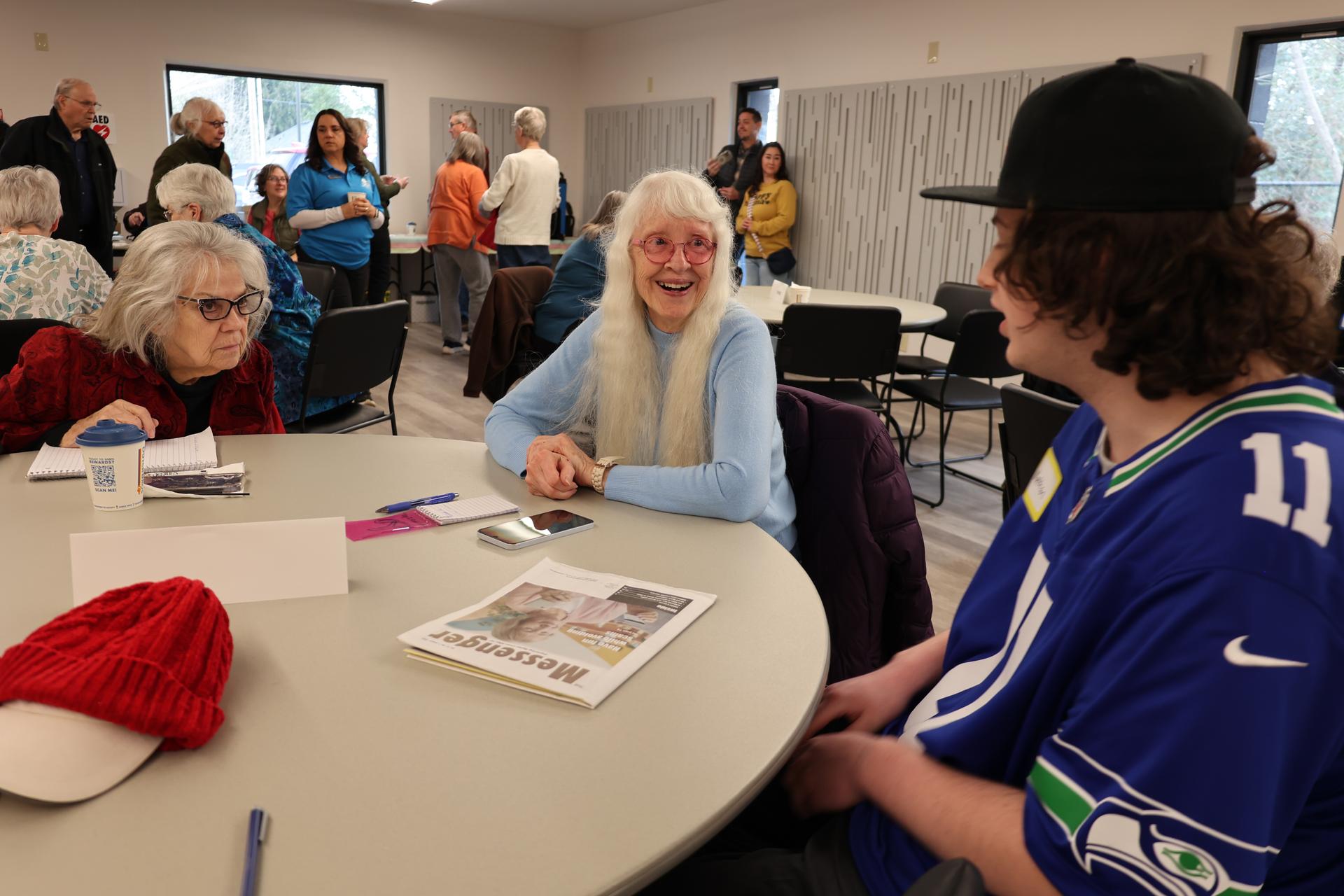 A student chats with two senior citizens