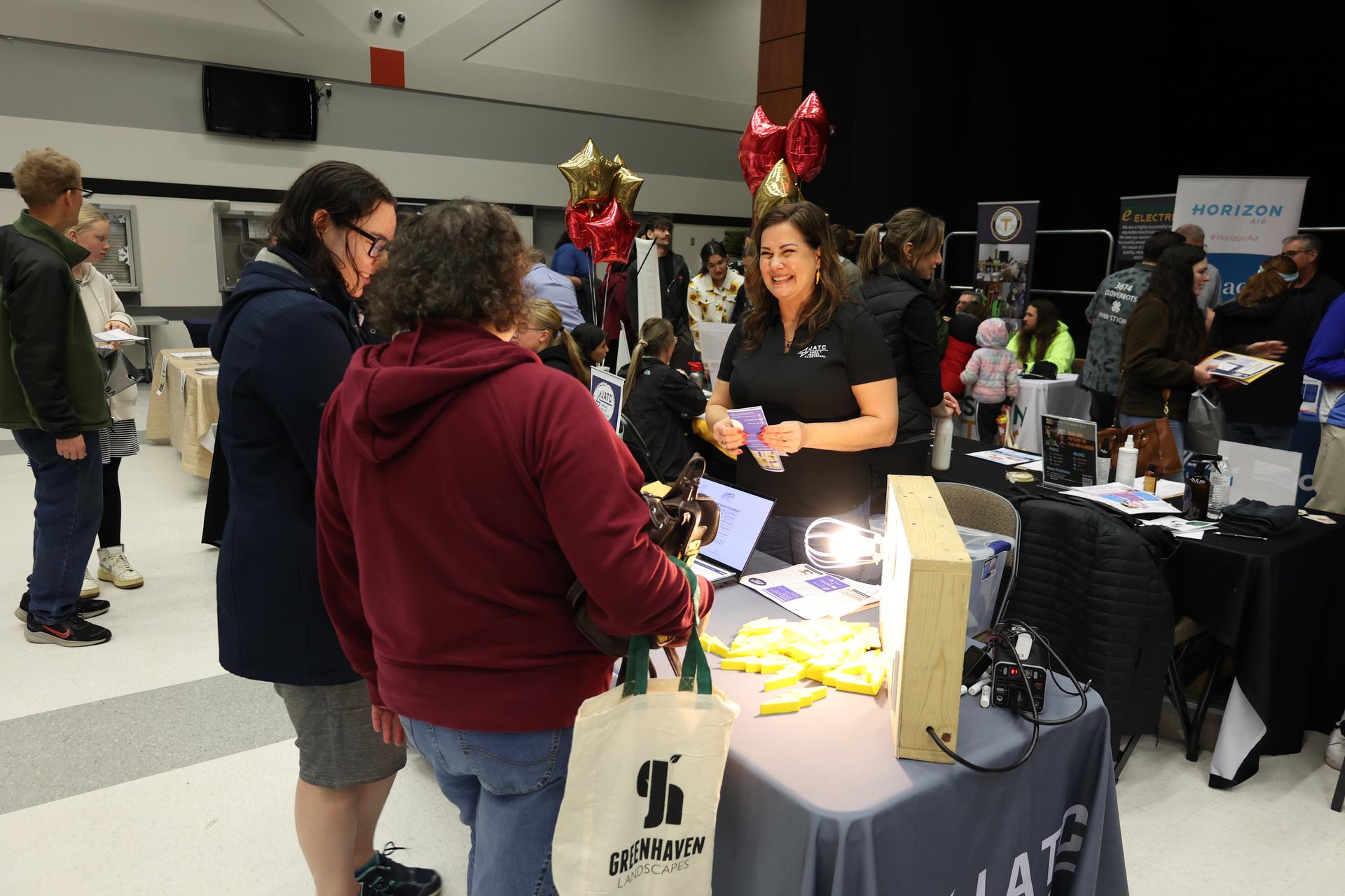 A representative of Area 1 Inside Electrical JATC speaks with attendees