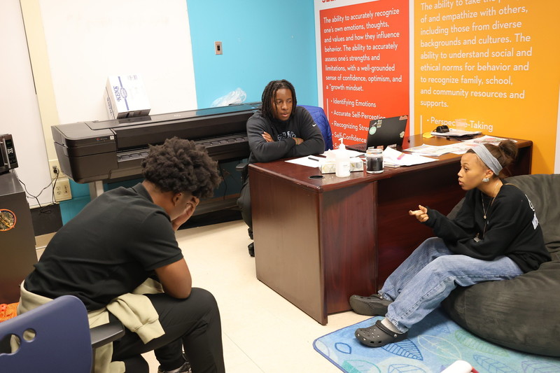 Un adulto y dos estudiantes en un círculo restaurativo