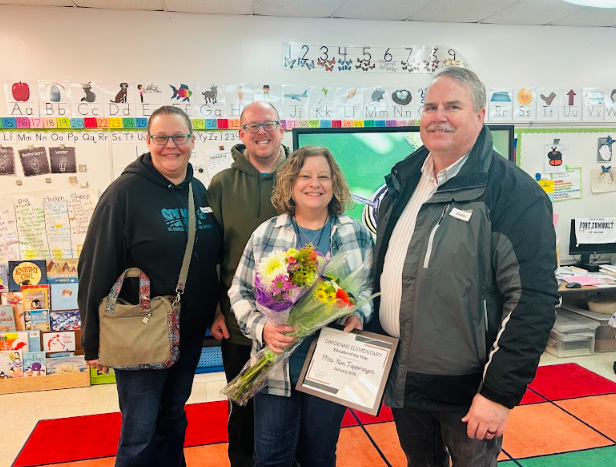 Educator of the Year poses with certificate and flowers