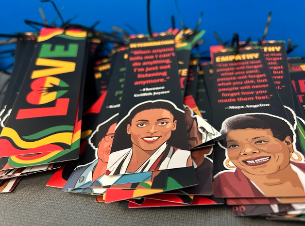 An adult guides students who have spread manipulatives and worksheets across the classroom floor