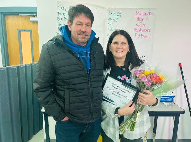 Employee of the Year poses with certificate and flowers