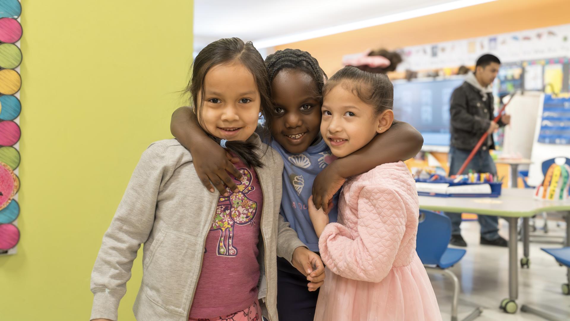 Three Goodnow School kindergartners pose for a group photo in their classroom.