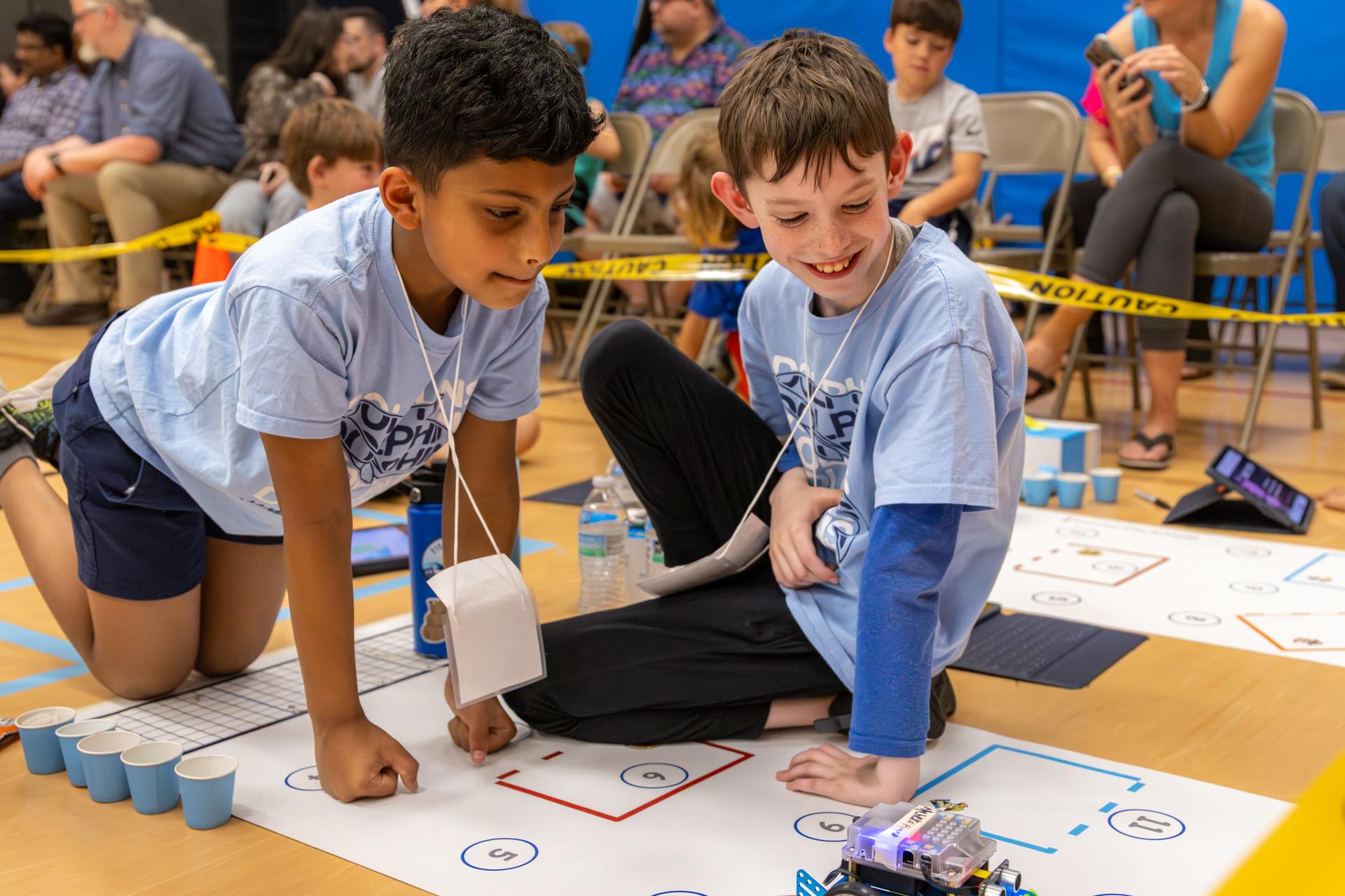 2 students looking at their robot