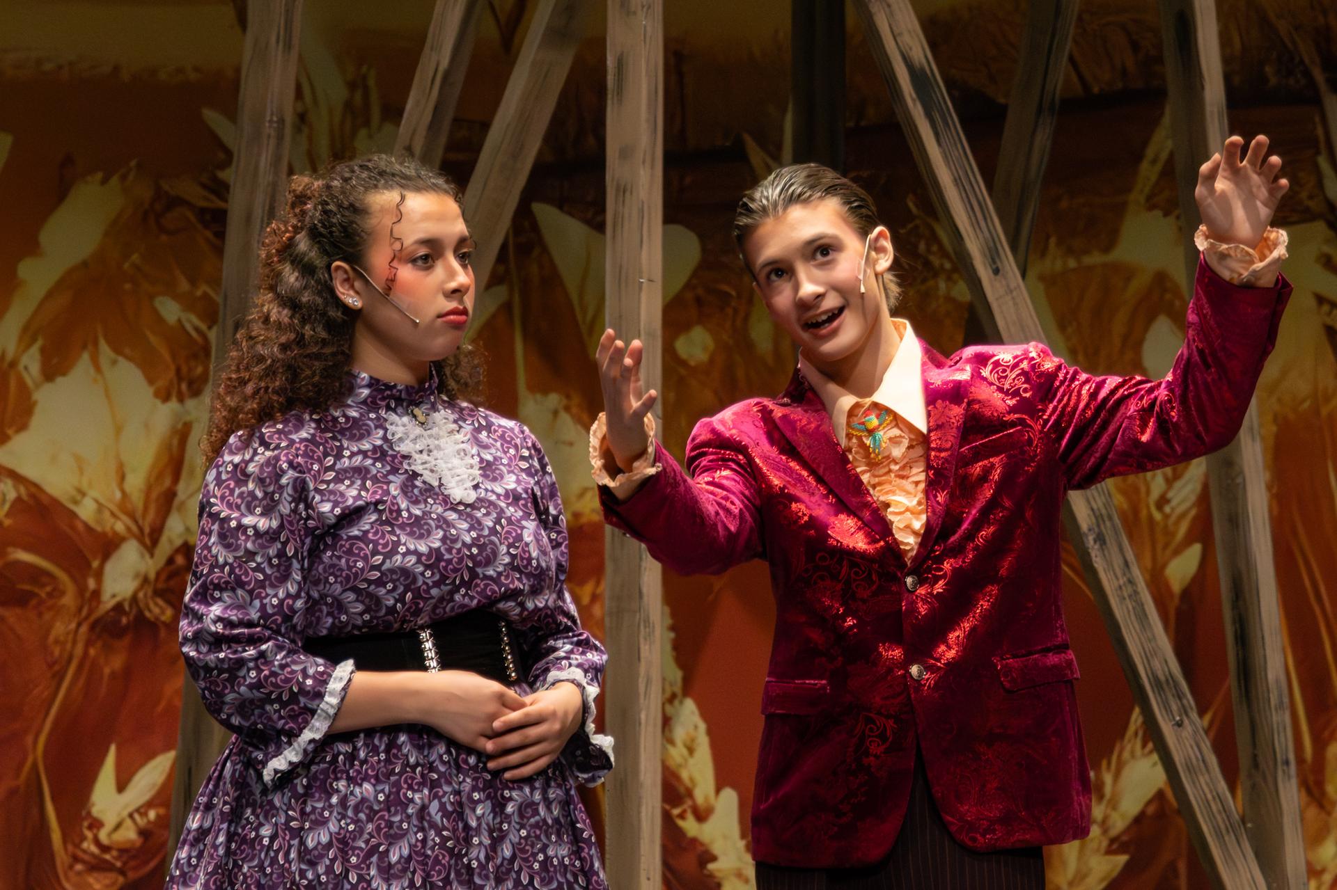 2 performers, male actor is singing to the audience