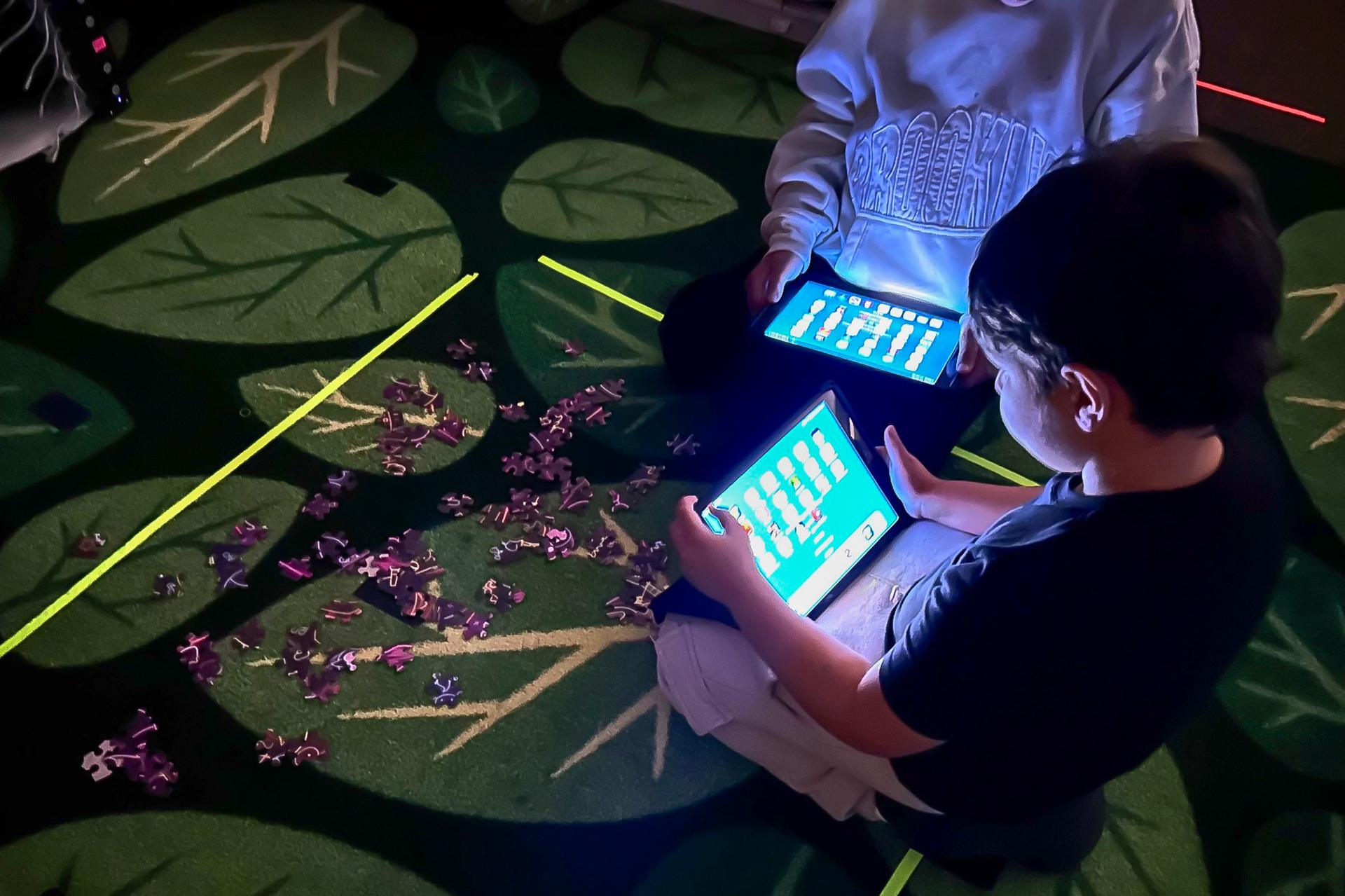 students playing games on ipad in the dark