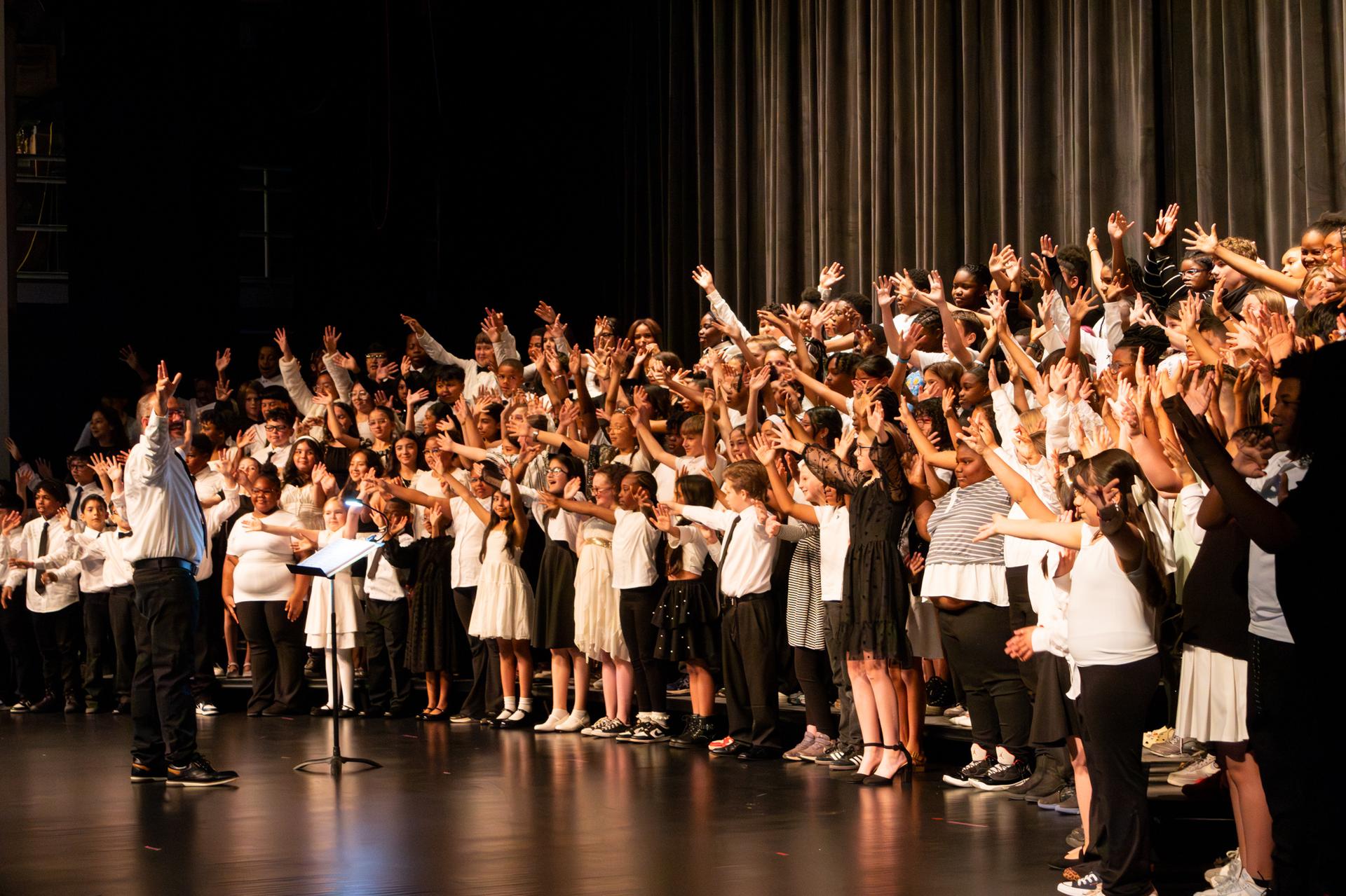 group image of choir with their hands raised