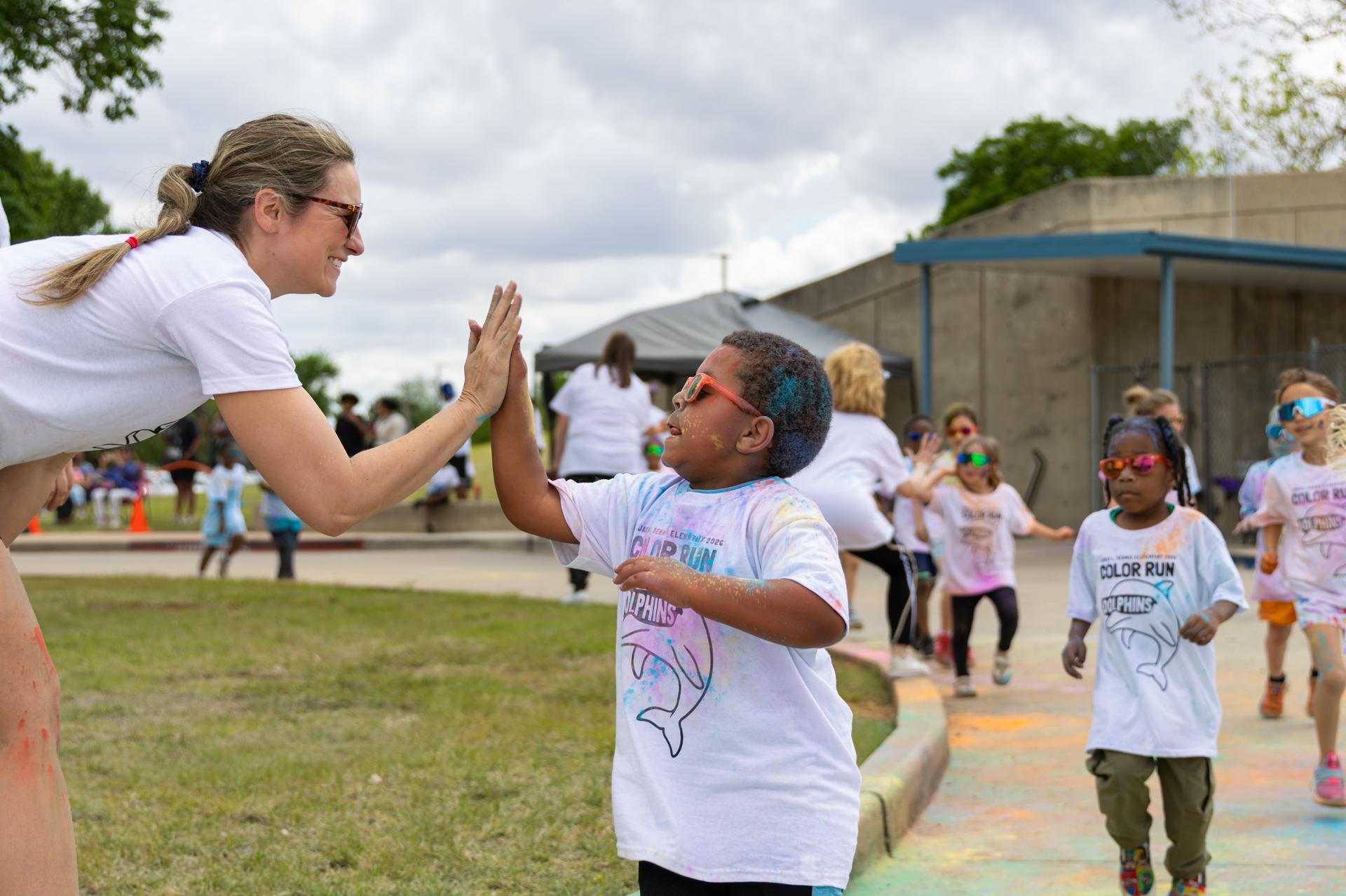 student going in for a high five with teacher