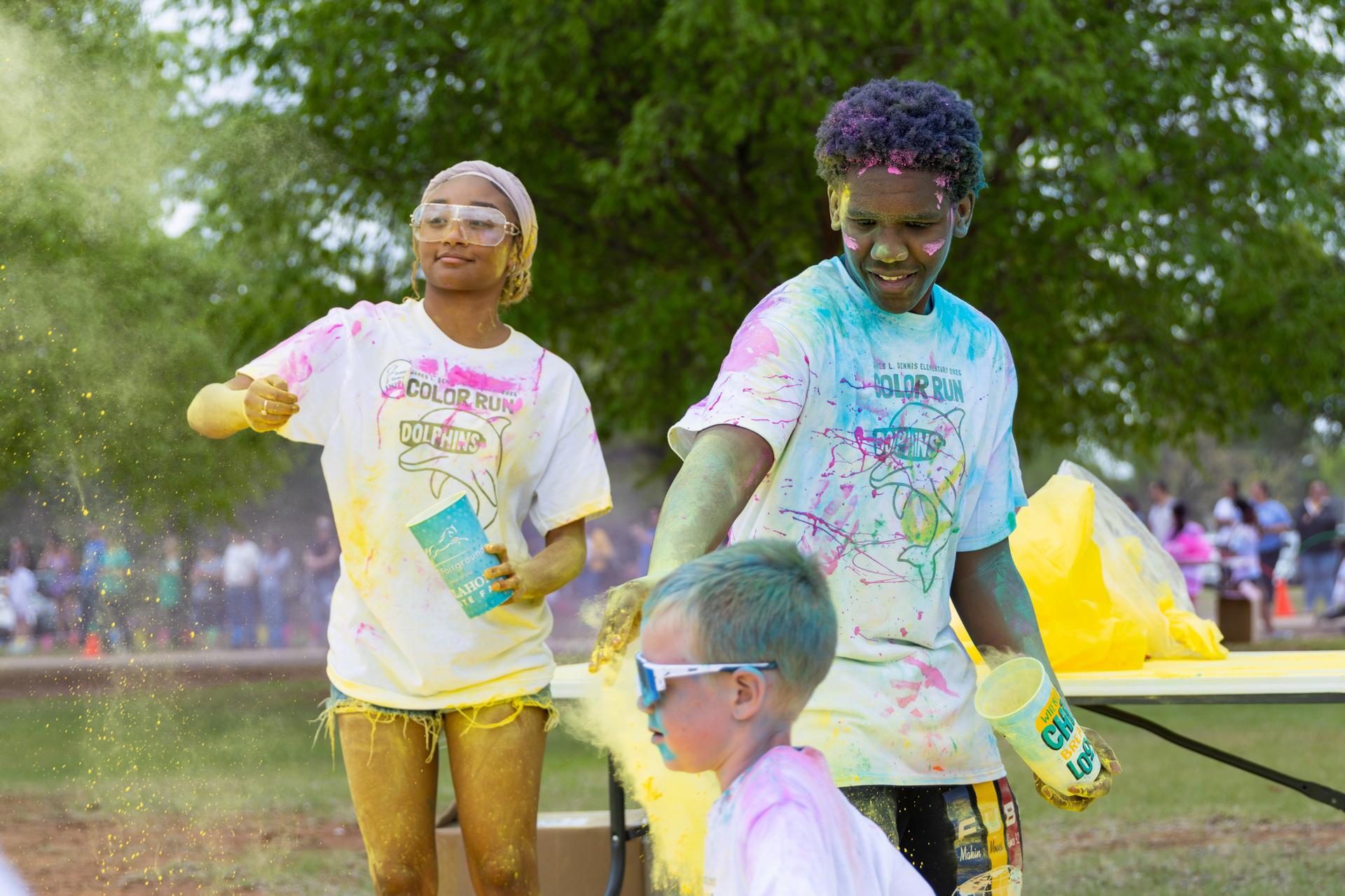 3 students in yellow chalk and paint
