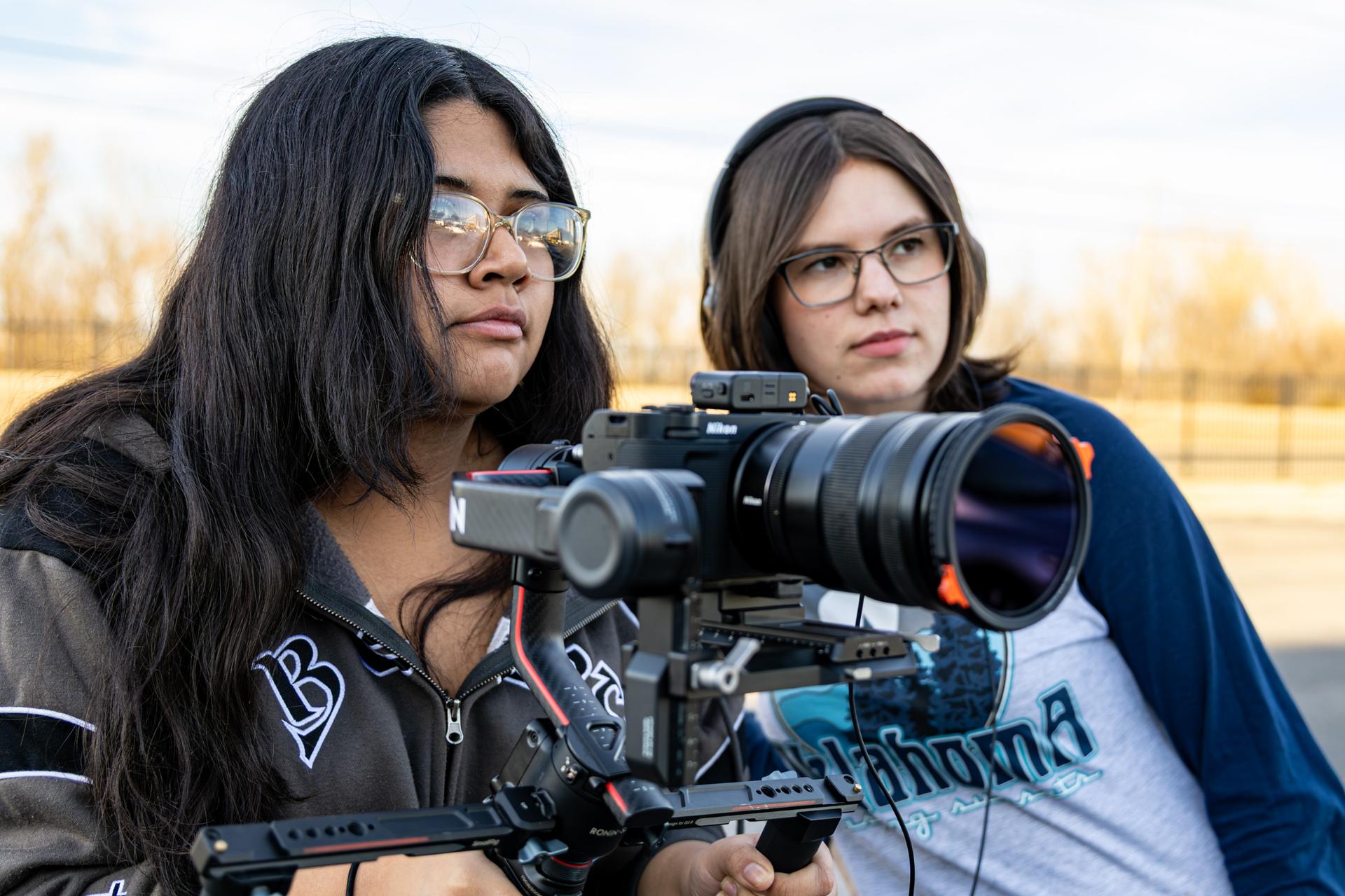 two students behind a camera