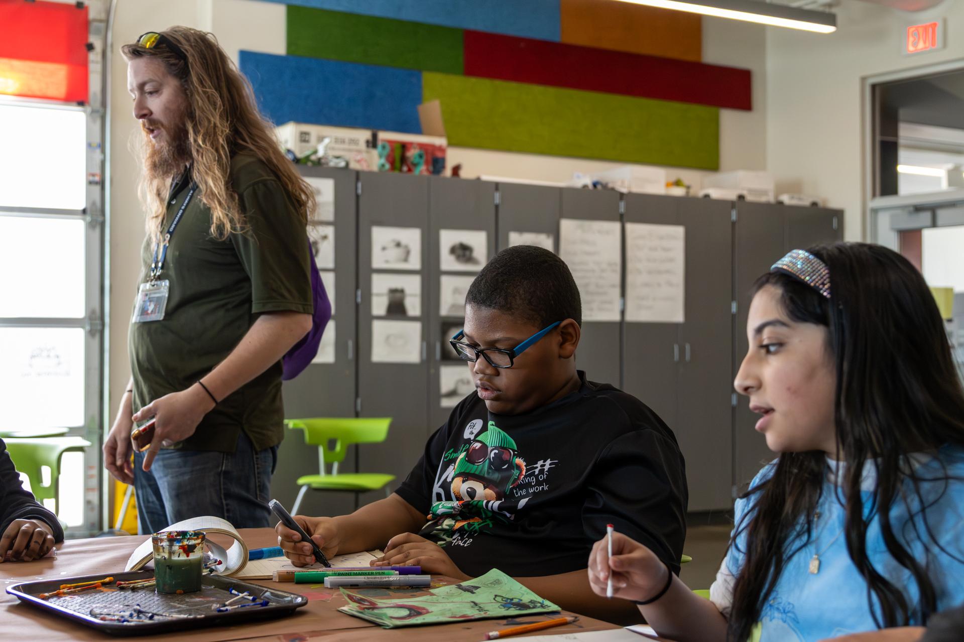2 students painting using a q-tip