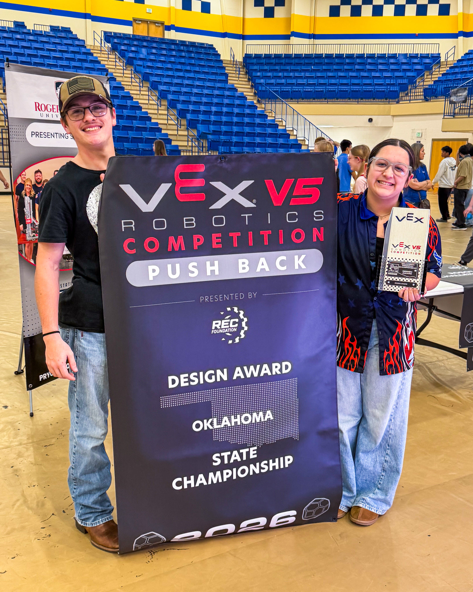 Alexander Palmer-Huggins and Kynnadee Brummett students holding championship banner
