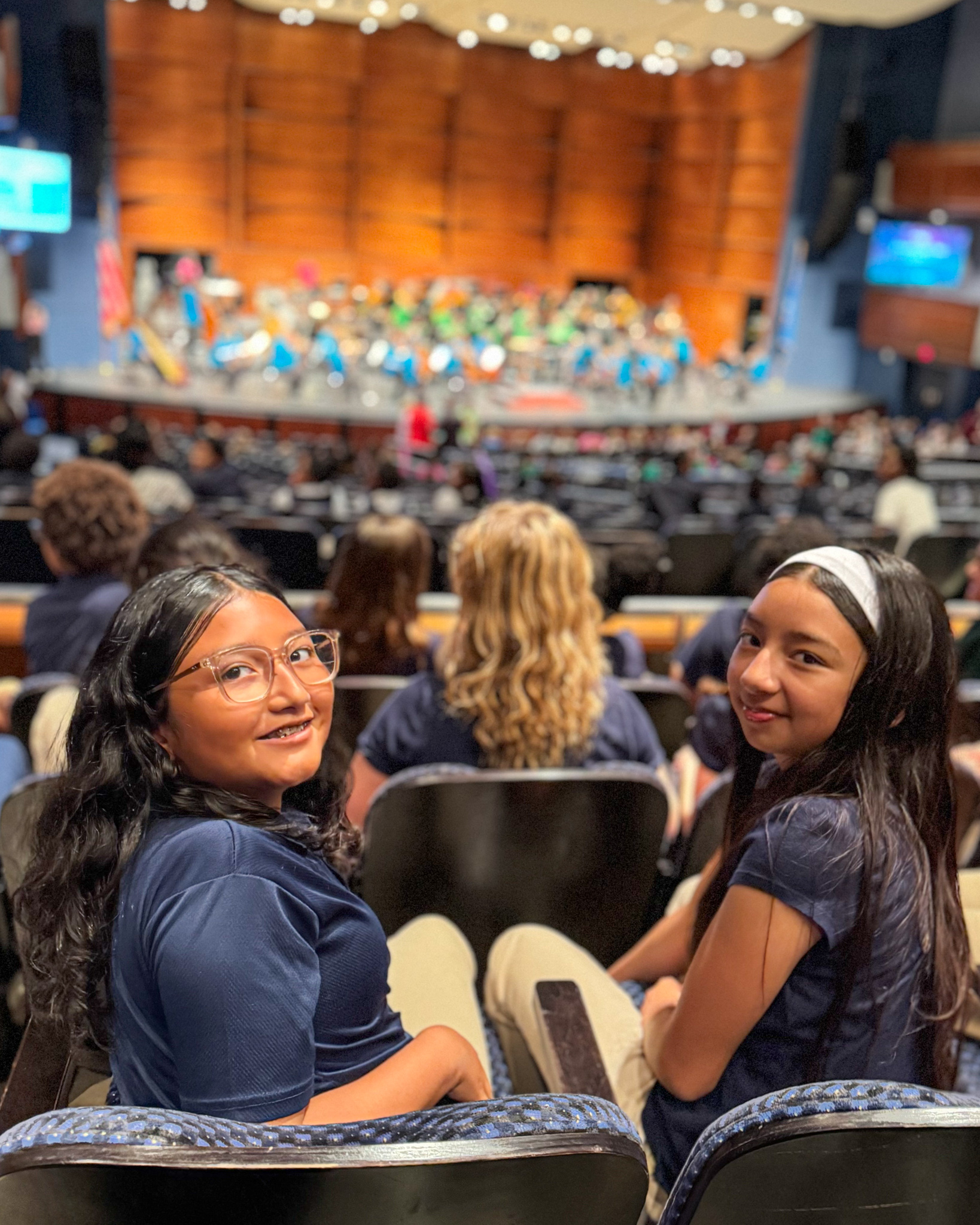 2 students turning around looking at the camera while in their seats