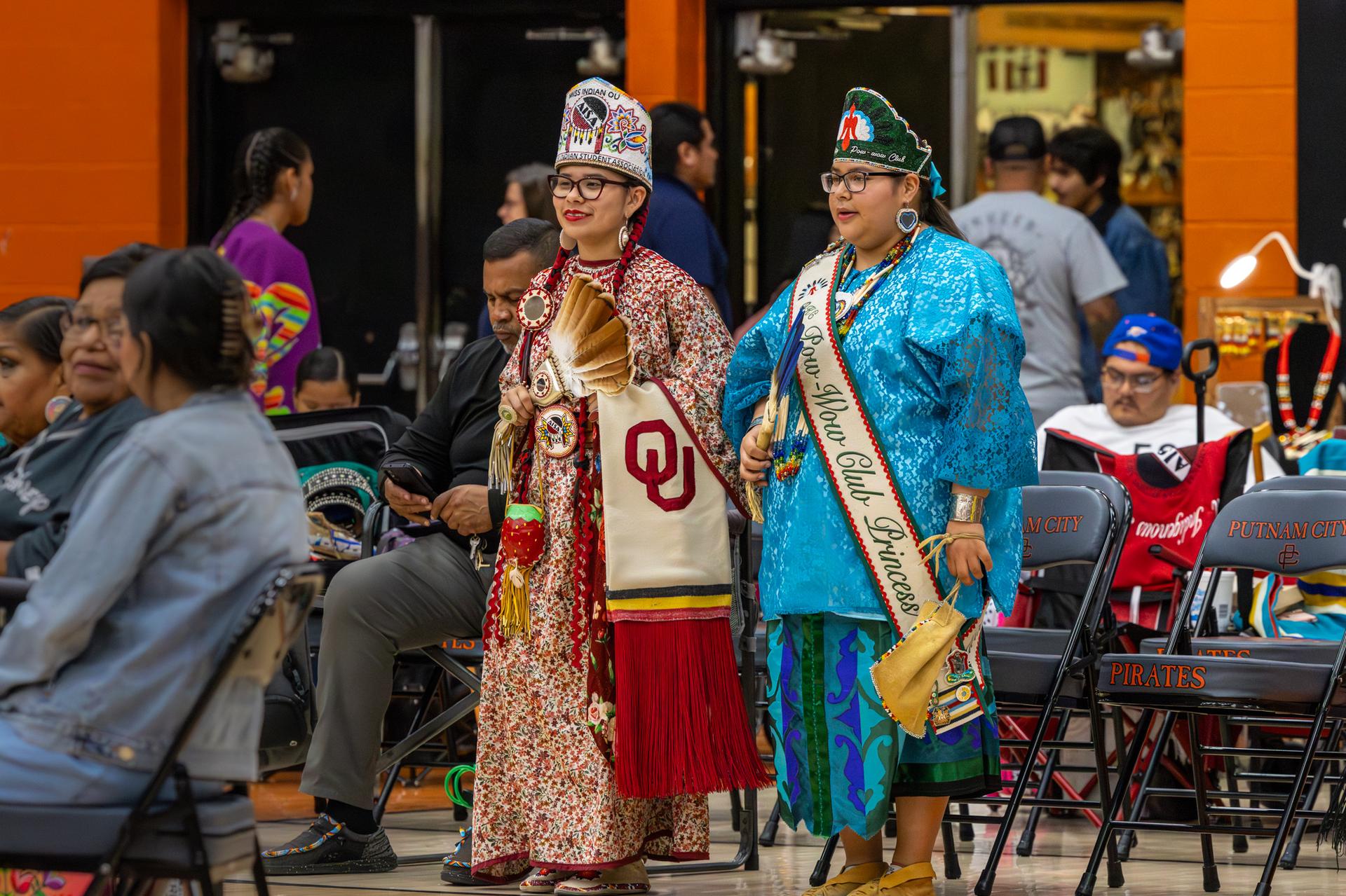 2 community members standing in traditional attire 