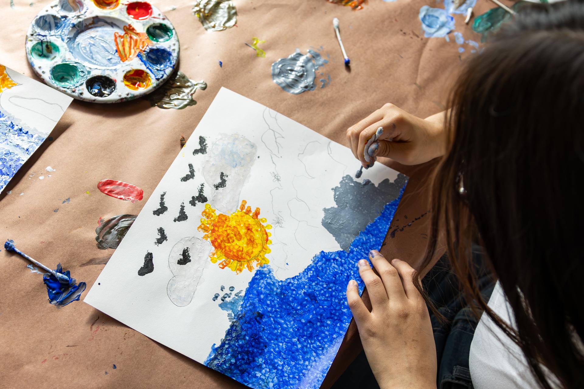 student is painting water and rocks with a q-tip