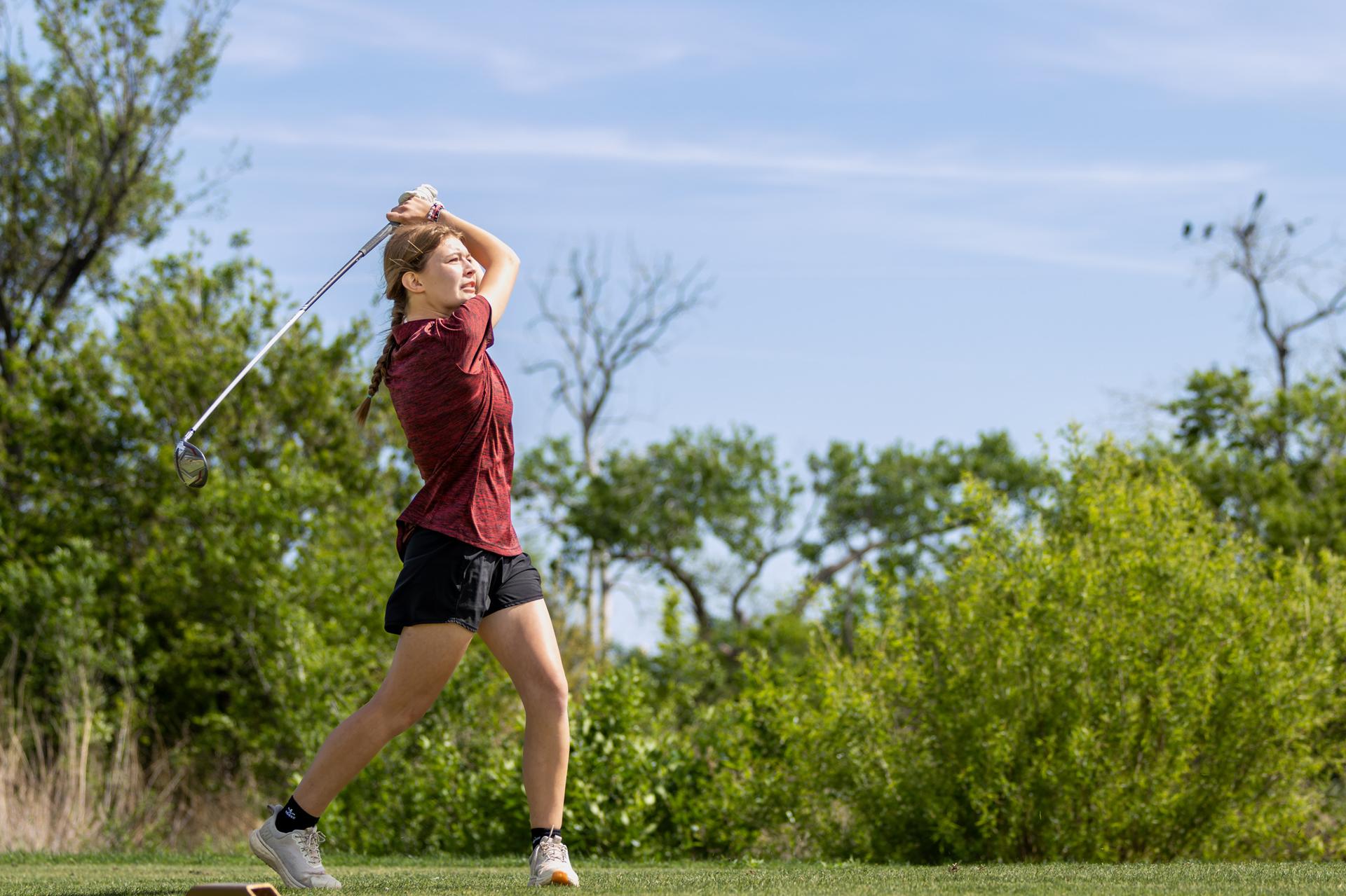 student in full swing on the golf course