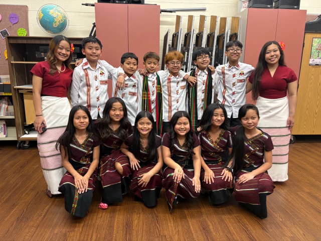 8 Burmese dancers standing in the back row, 6 Burmese dancers kneeling in the front row.