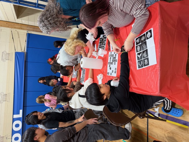 Students receiving henna on their hands.