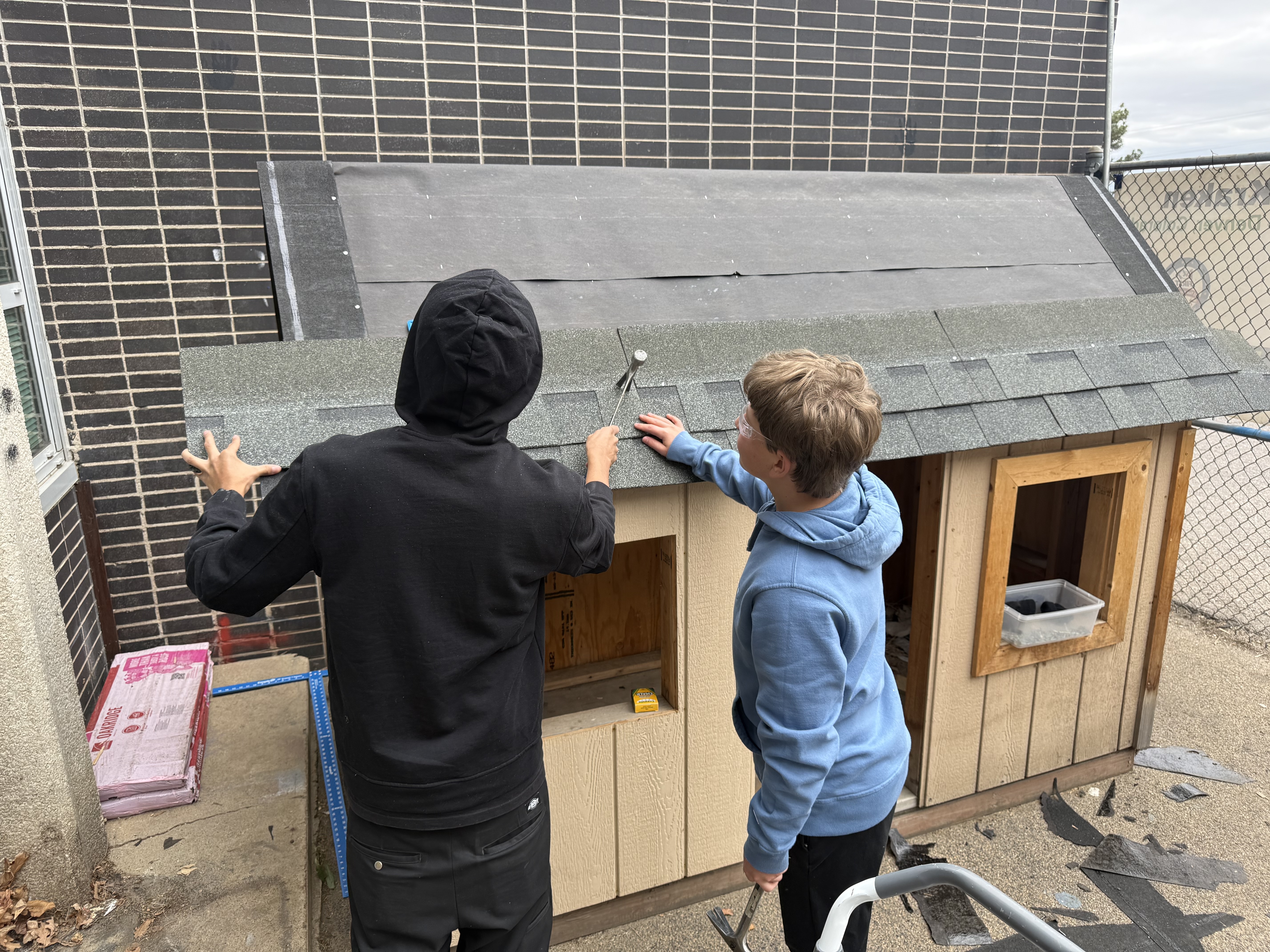 students apply roofing materials