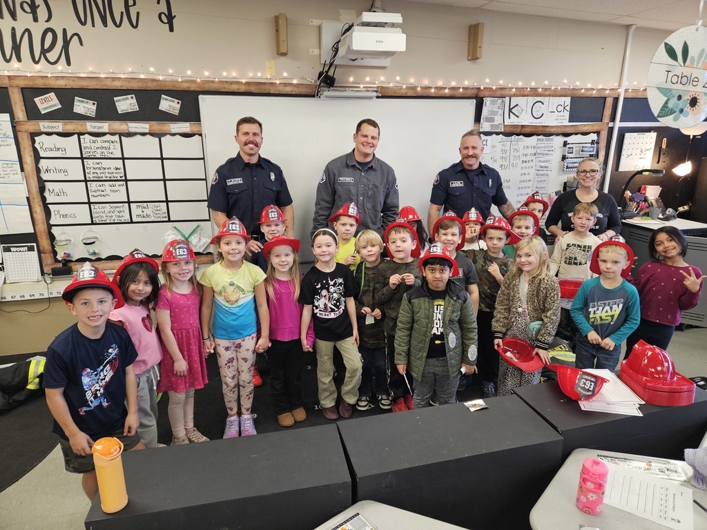 Westwood student classroom posing with local first responders in plastic fire hats