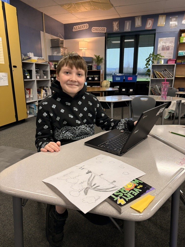 Southwood student smiling sitting at desk with Chromebook