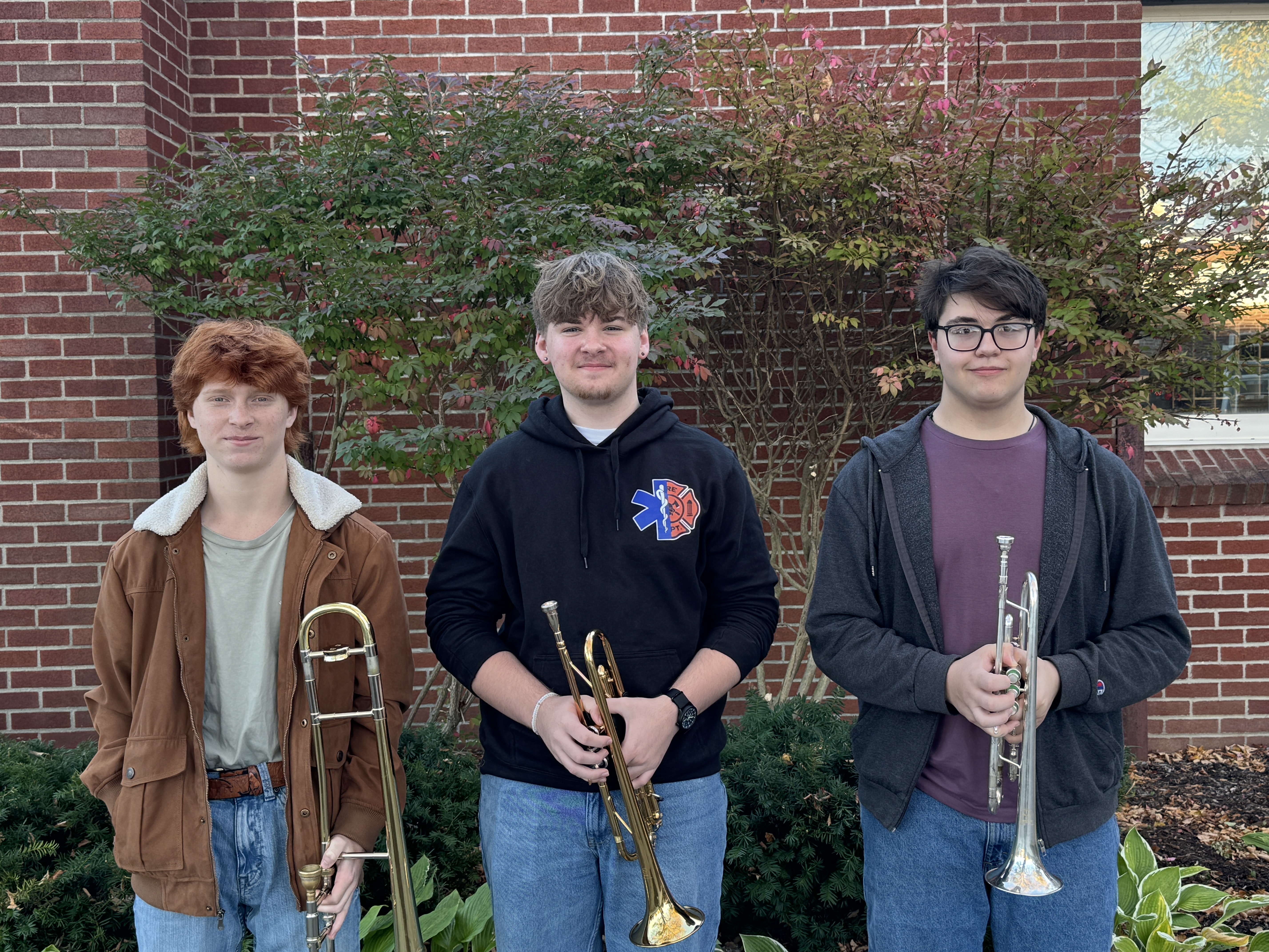 3 music students standing with their instruments