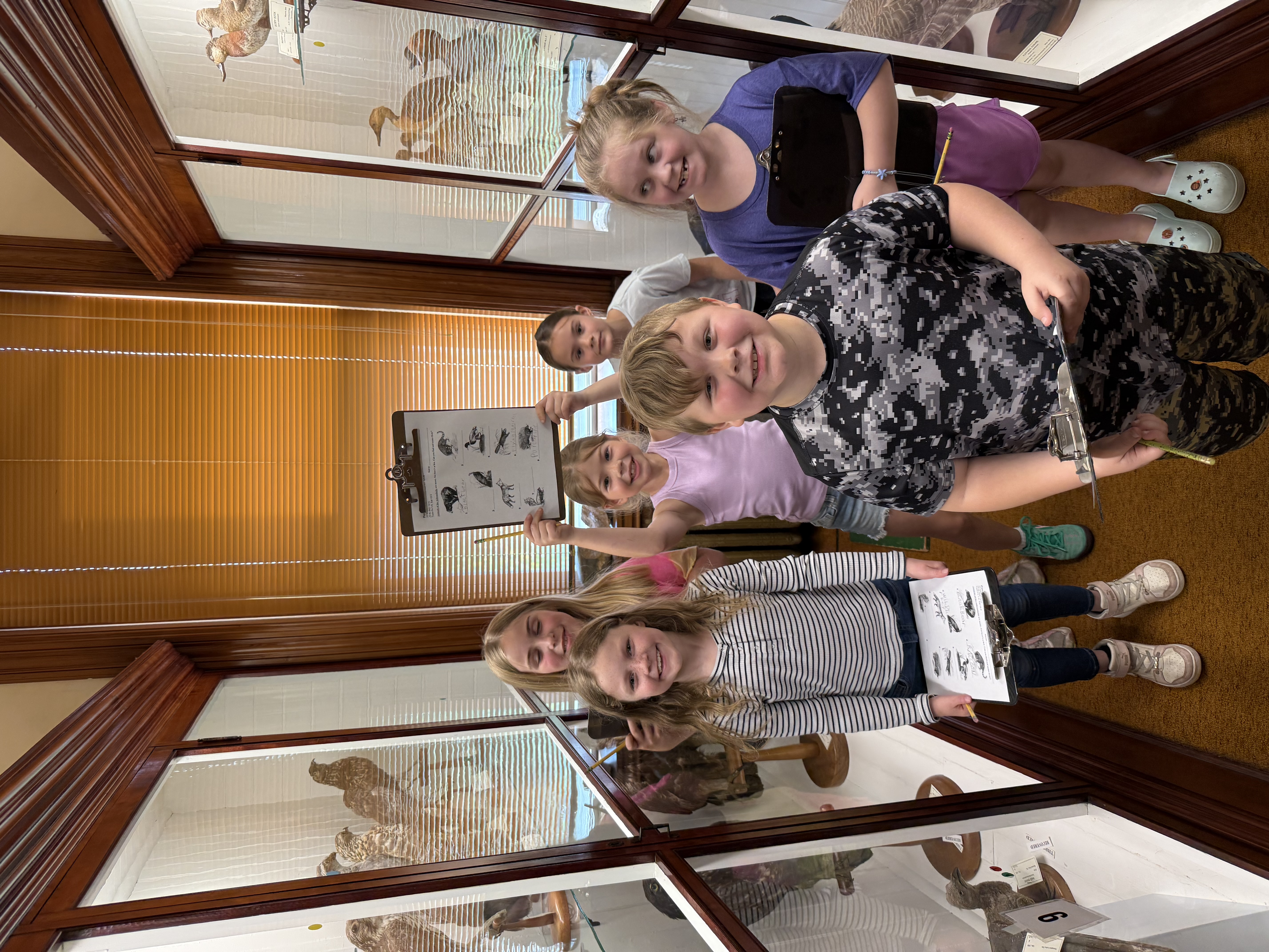Second graders holding up their assignment at the Pember Library Field Trip
