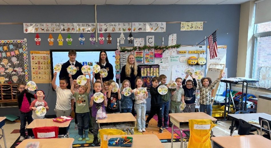 FFA Jr/Sr Students stand behind a group of MJT students holding up their Four Seasons on a Farm project