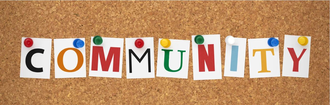 bulletin board with colorful letters that spell Community pinned up on board