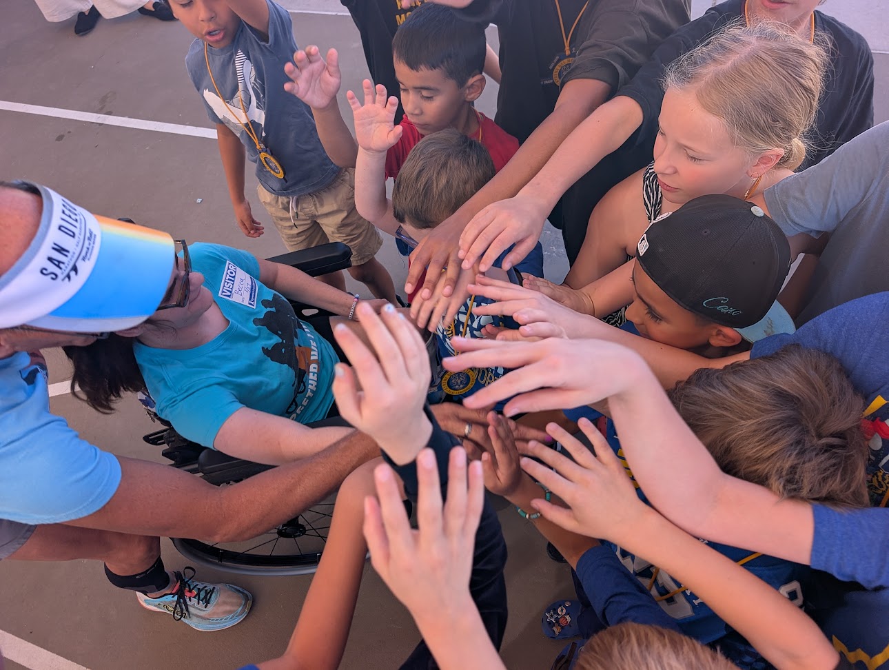 students hands in middle with adult in wheelchair