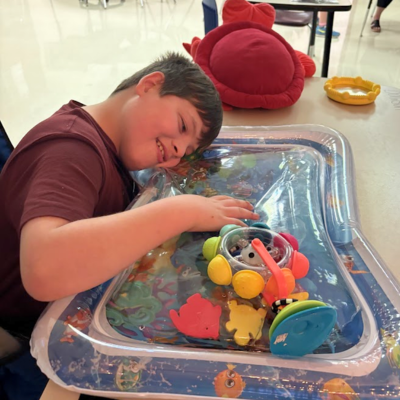 Student touching sensory items