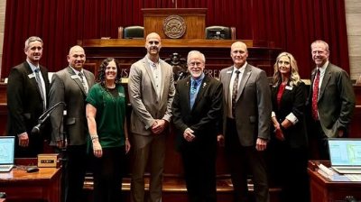 Dr. Cody Hirschi next to several superintendents and lawmakers