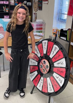 Girl standing next to spinning prize wheel