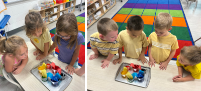 Kindergartners looking at various colors of paint in cups.
