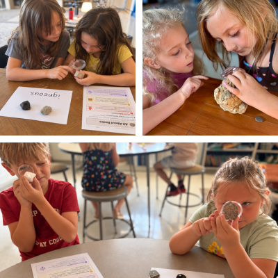 Students work in paris to examine rocks with magnifying glasses