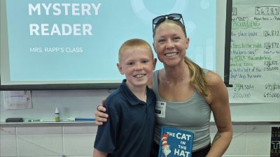 Lucas V. and his mom holding a book