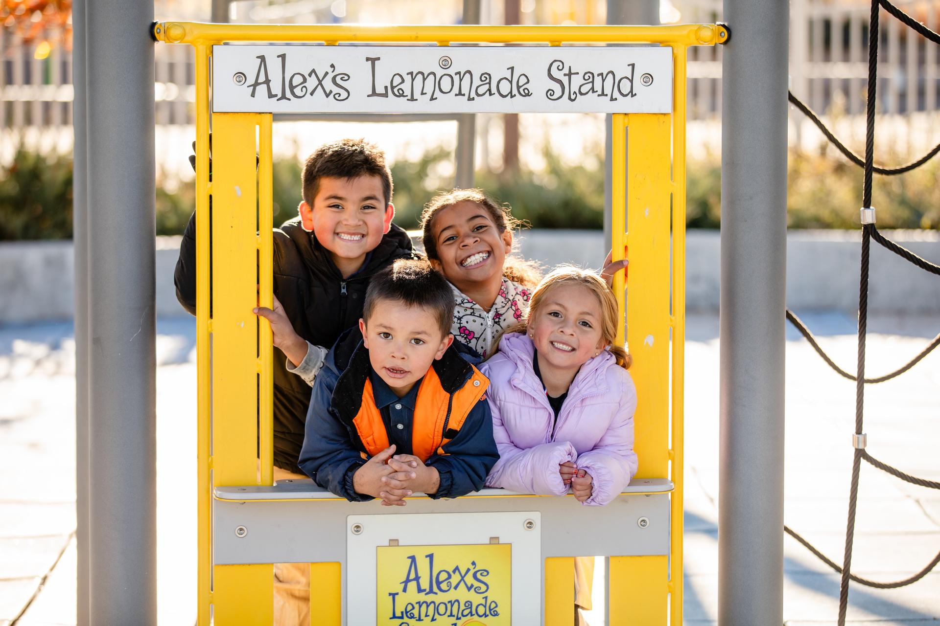 Four students smile for a photo on the Swansea Elementary Playground. 