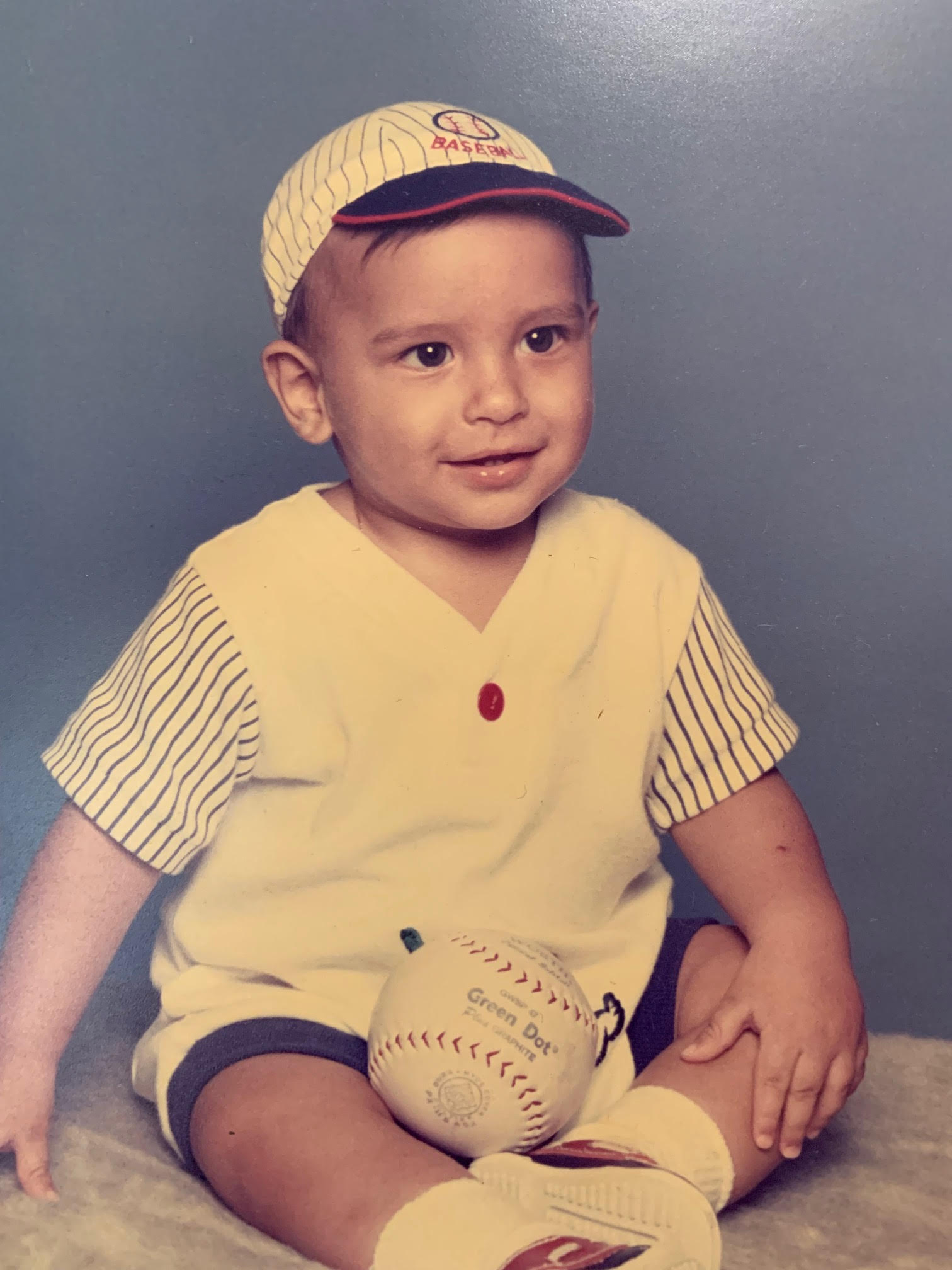 Pictured: an infant laying on top of a floral blanket.