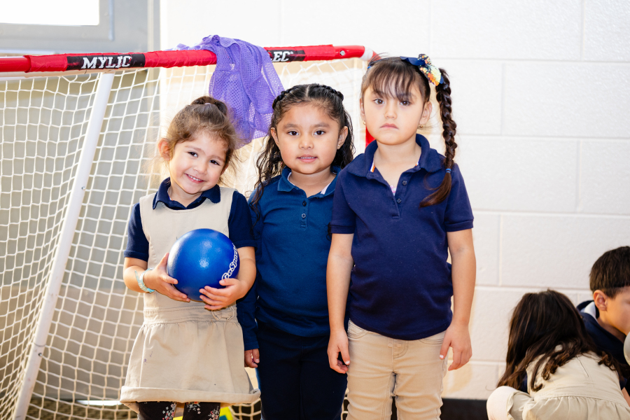 Three students pose for a photo in gym class. 